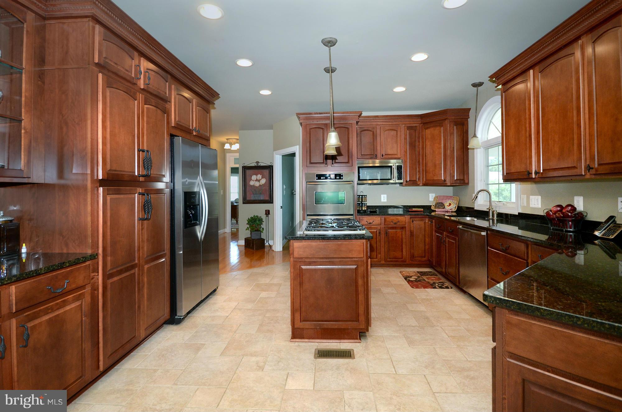 3401 Meredith Ridge Road Phoenix, MD 21131 - Photo 6 of 28 a kitchen with stainless steel appliances granite countertop a refrigerator a sink and a stove