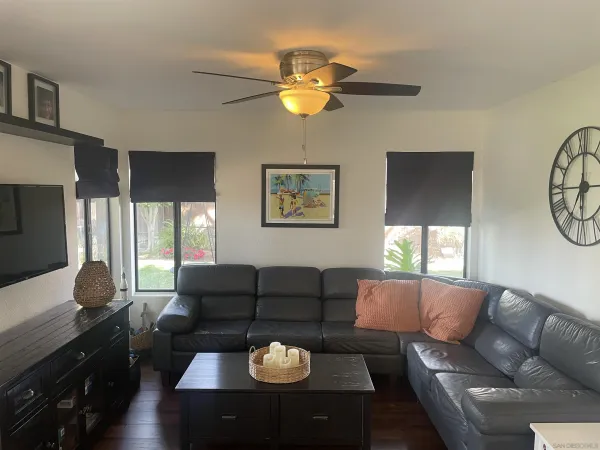 a living room with furniture a chandelier and a flat screen tv