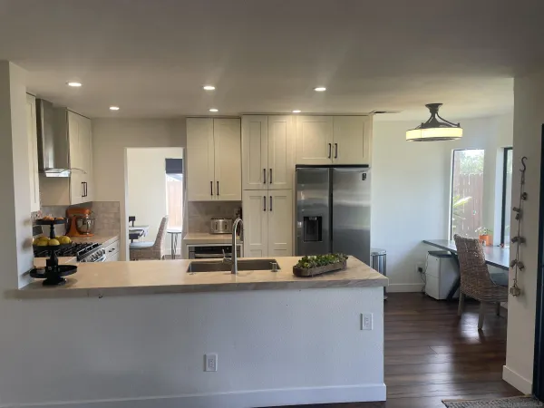 a kitchen with refrigerator and chairs