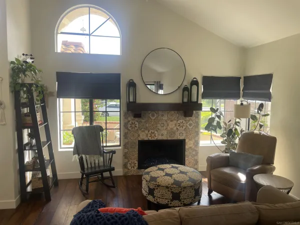 a living room with furniture a fireplace and a large window