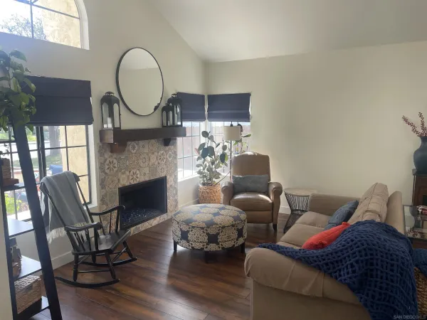 a living room with furniture a fireplace and a large window