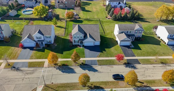 an aerial view of residential houses with outdoor space and parking