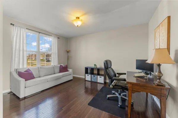 a living room with furniture and a flat screen tv with wooden floor