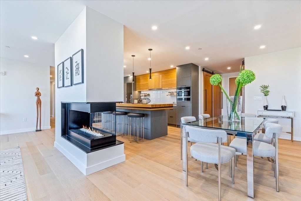 76 Wareham Street, Unit 5C Boston, MA 02118 - Photo 3 of 29 a living room with stainless steel appliances kitchen island granite countertop a table chairs and a fireplace