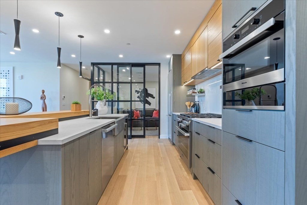 76 Wareham Street, Unit 5C Boston, MA 02118 - Photo 6 of 29 a kitchen with stainless steel appliances granite countertop lots of counter top space and wooden floor