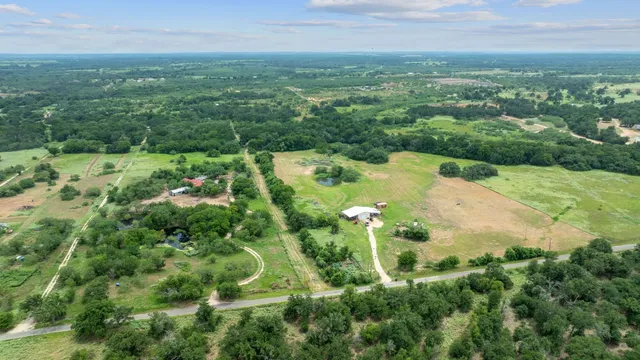 an aerial view of residential houses with outdoor space and trees all around