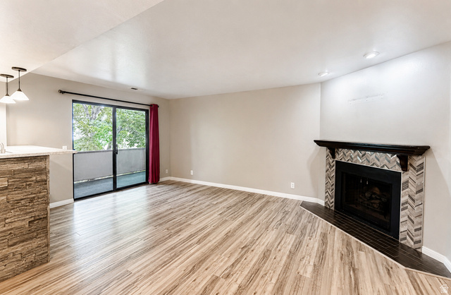 6907 South 745th Street East, Unit G Midvale, UT 84047 - Photo 9 of 30 Spacious main living area with fireplace and balcony access