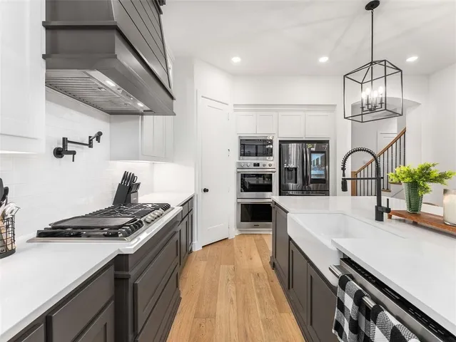 a kitchen with stainless steel appliances a sink stove and cabinets