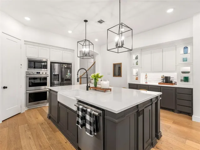 a kitchen with stainless steel appliances granite countertop a stove and a sink with cabinets
