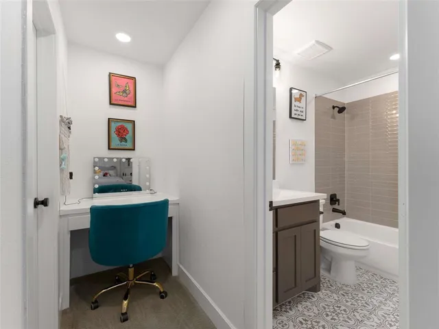 a bedroom with a bed and a flat tv screen on dresser