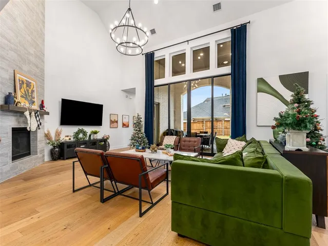 a dining room with furniture a floor to ceiling window and wooden floor