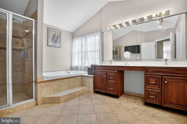 a bathroom with a tub sink and mirror