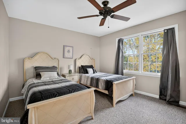 a bedroom with two beds and a large window