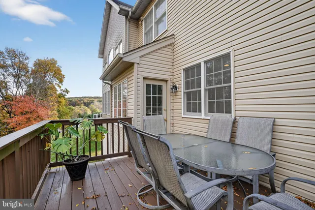 a balcony with wooden floor table and chairs