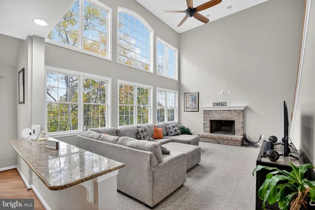 a living room with furniture a fireplace and a floor to ceiling window