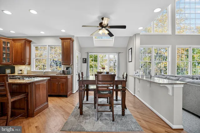 a kitchen with stainless steel appliances granite countertop table chairs stove and sink
