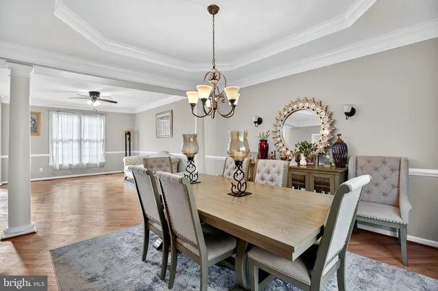a dining room with furniture a chandelier and wooden floor