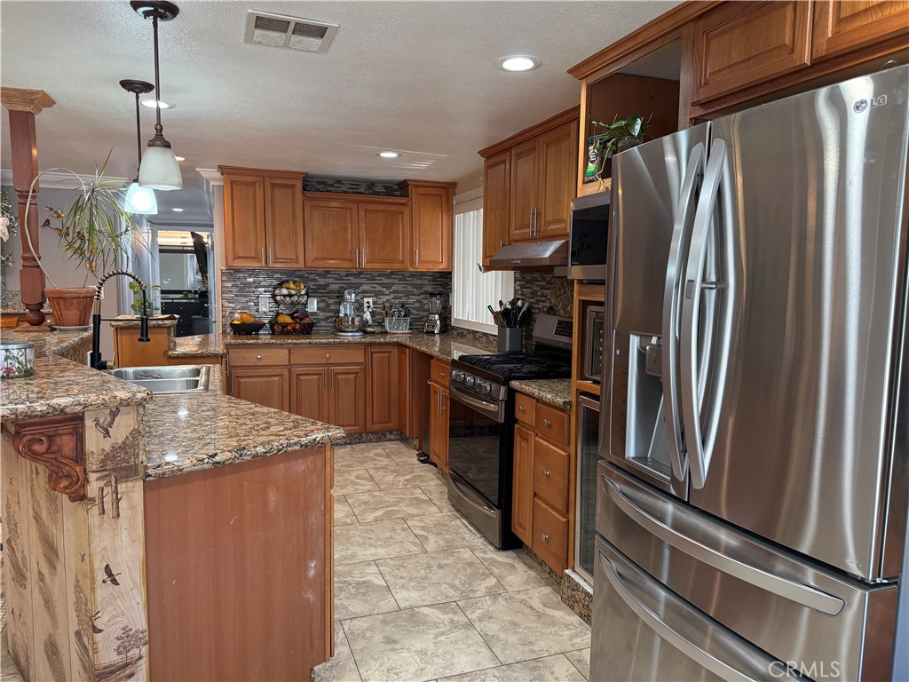 20683 Waalew Road, Unit B37 Apple Valley, CA 92307 - Photo 14 of 24 a kitchen with stainless steel appliances granite countertop a refrigerator a sink a stove and a refrigerator