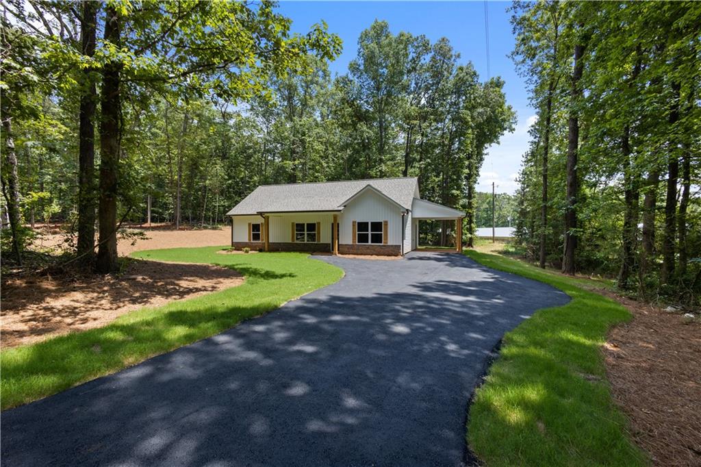 a aerial view of a house with backyard and trees