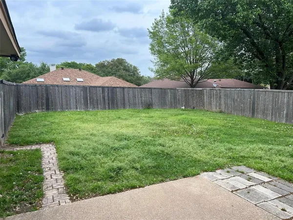a view of a yard with wooden fence