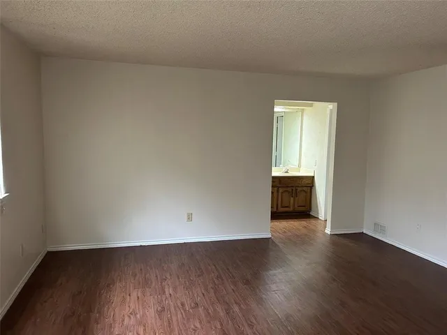 an empty room with wooden floor and closet