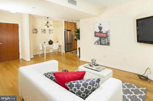 915 E Street Northwest, Unit 714 Washington, DC 20004 - Photo 6 of 14 a living room with furniture and a flat screen tv