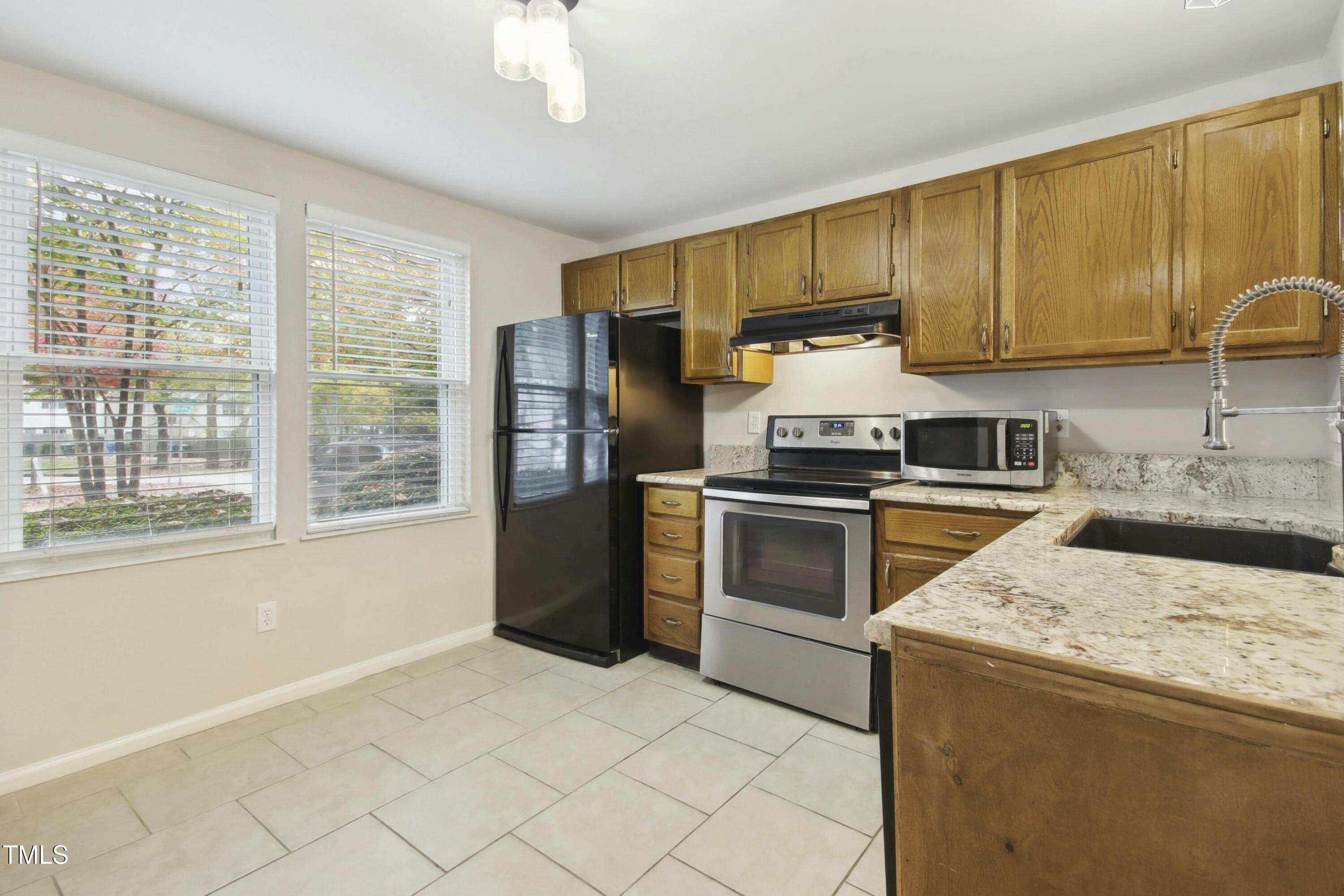 7803 Stephanie Lane Raleigh, NC 27615 - Photo 11 of 30 a kitchen with a stove a sink and a refrigerator