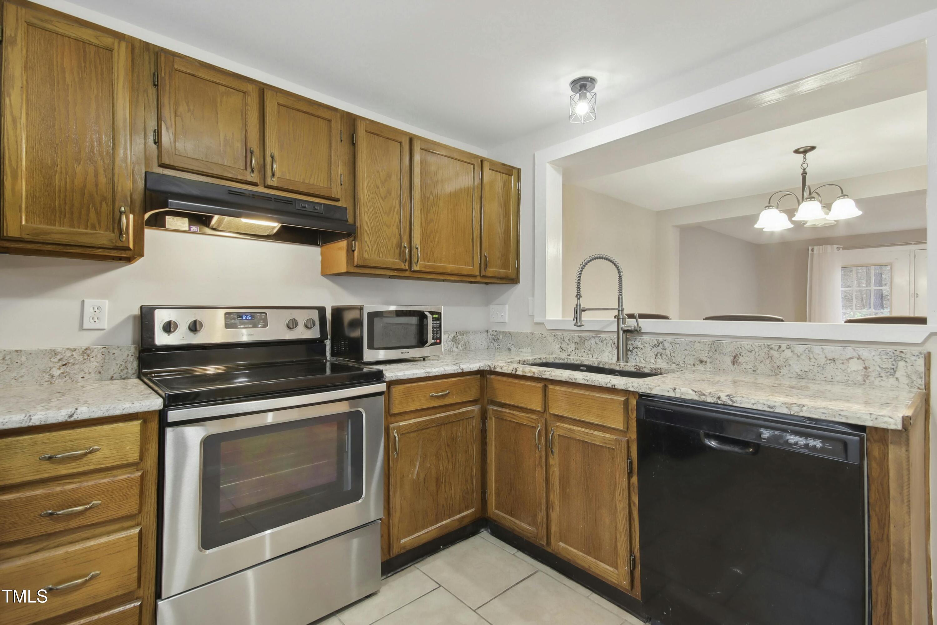 7803 Stephanie Lane Raleigh, NC 27615 - Photo 12 of 30 a kitchen with granite countertop a sink stainless steel appliances and cabinets