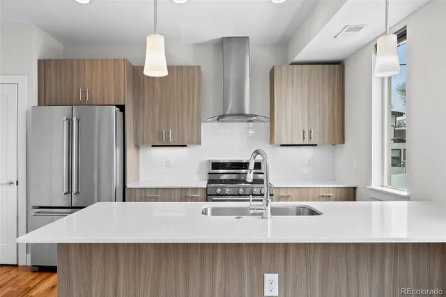 a kitchen with stainless steel appliances a stove refrigerator sink and cabinets