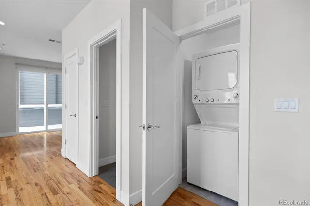 a view of a hallway with wooden floor and closet