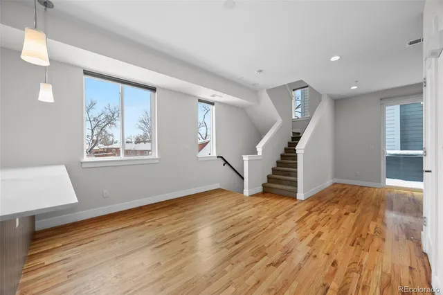 a view of empty room with wooden floor and stairs