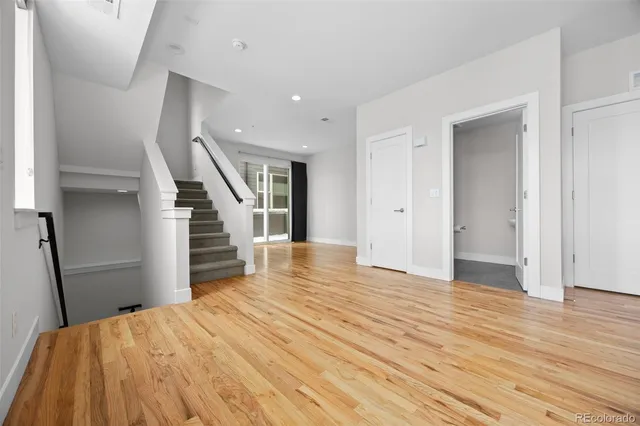 a view of a livingroom with wooden floor and stairs