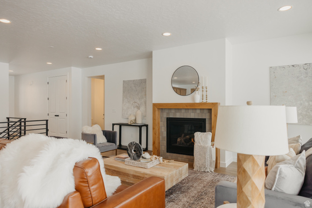 1066n South State Road, Unit ATWOOD Salem, UT 84653 - Photo 9 of 29 Living area featuring a fireplace with a wood-finish mantel and tile surround, recessed lighting, and white walls