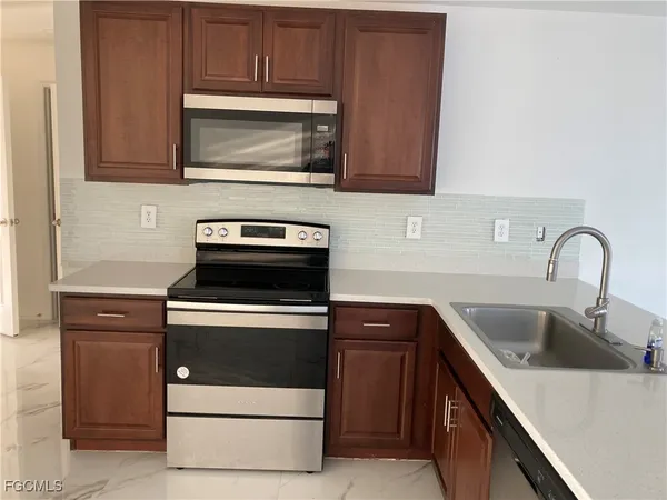 a kitchen with sink a microwave and stove