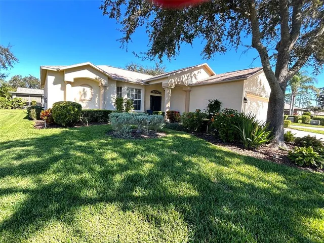 a view of a house with a big yard and large tree