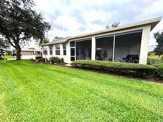 a front view of a house with a garden and trees