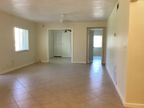 a view of a hallway with wooden floor and a bathroom