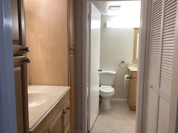 a bathroom with a granite countertop toilet and a sink