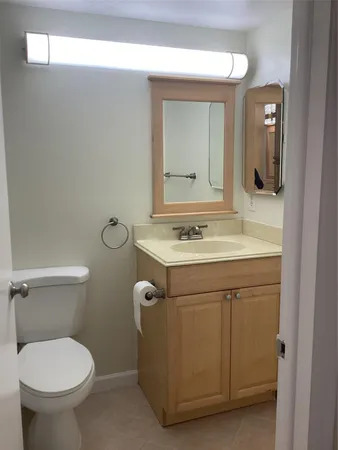 a bathroom with a sink toilet and mirror