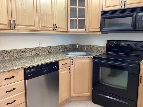a kitchen with granite countertop a stove microwave and sink