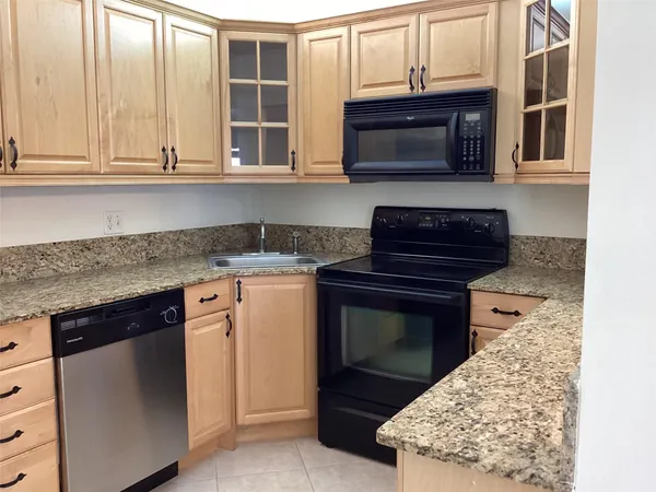 a kitchen with stainless steel appliances granite countertop a stove microwave and cabinets
