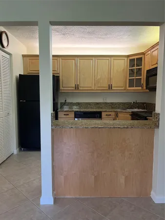 a kitchen with stainless steel appliances granite countertop a refrigerator and a stove
