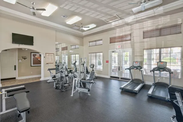 a room with gym equipment and large windows