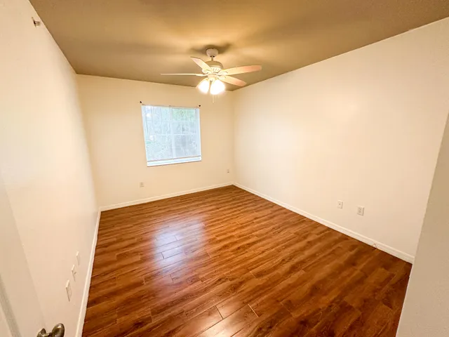 a view of empty room with wooden floor