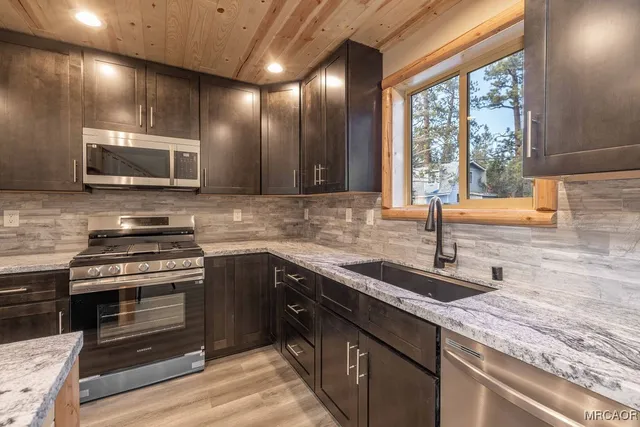 a kitchen with granite countertop a sink and cabinets