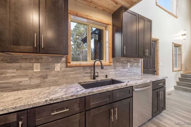 an empty room with wooden floor ceiling fan and windows