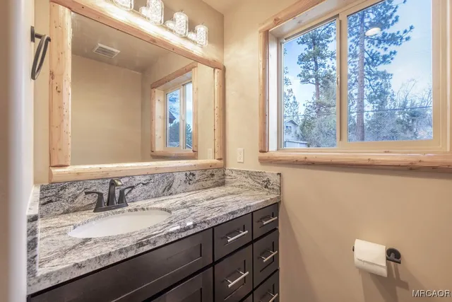 a view of an empty room with wooden floor and a ceiling fan