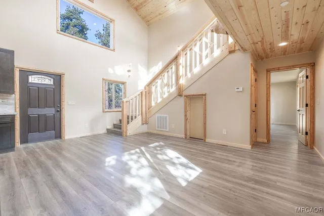 a kitchen with stainless steel appliances granite countertop a sink a stove a microwave and wooden cabinets