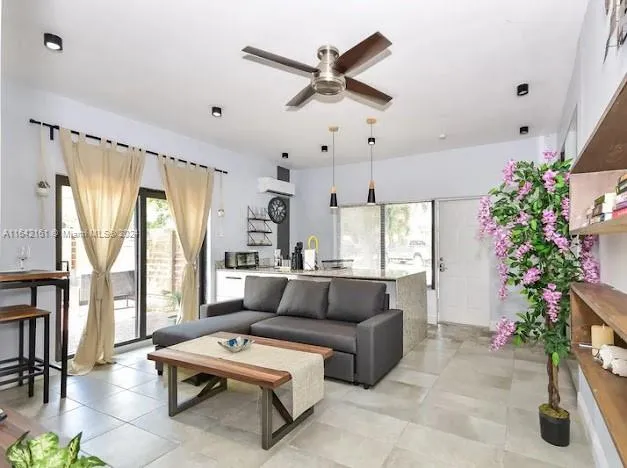 a living room with furniture potted plant and a large window