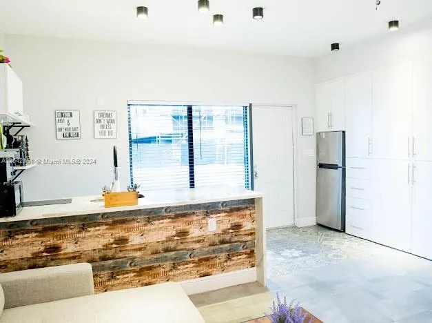 a kitchen with a sink a counter and chairs